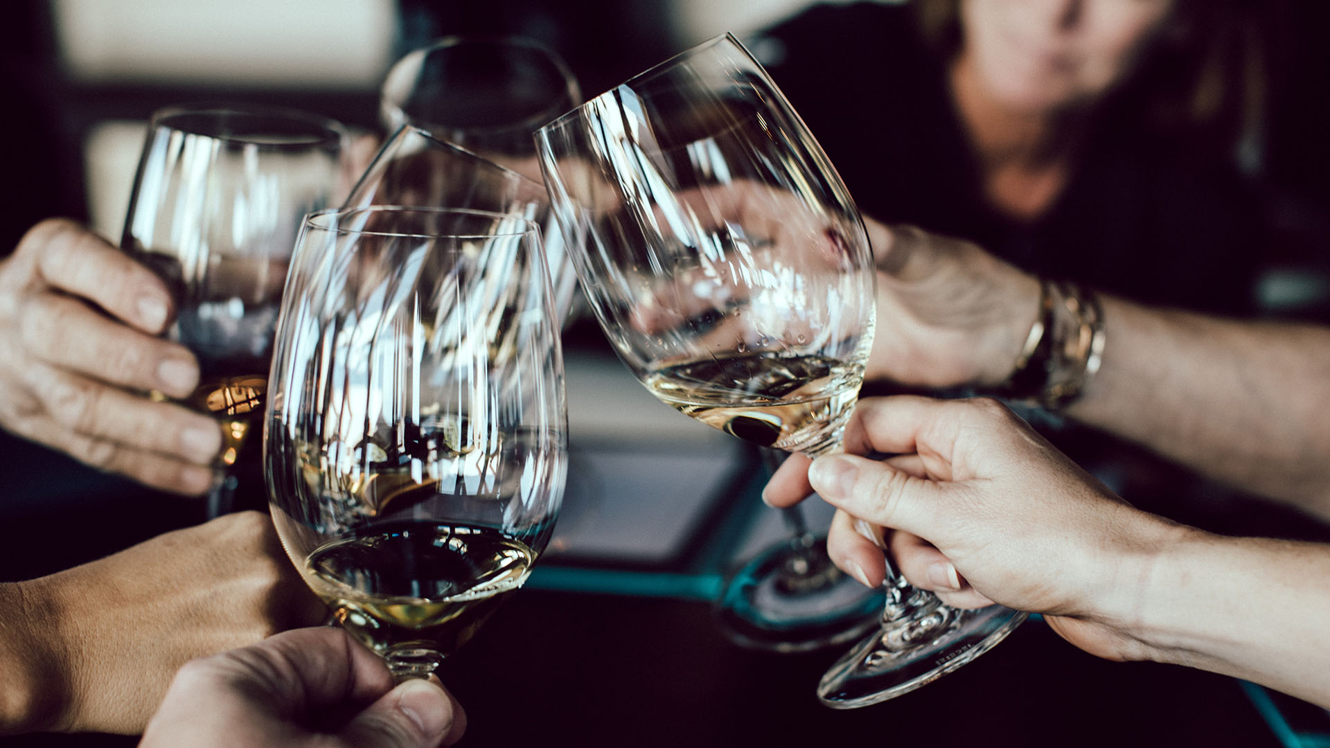 5 people toasting with wine glasses.