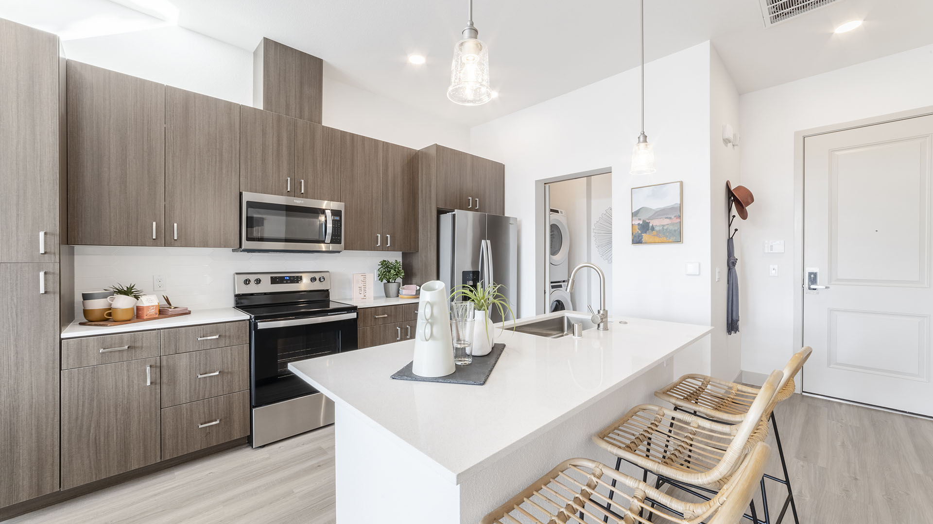 Kitchen with wood floor and cabinets, tiled backsplash, stainless steel appliances, and breakfast bar.